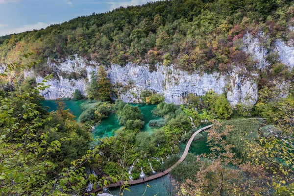 风景如画的瀑布般的湖水点缀着翡翠般的湖水 去克罗地亚旅行 游客用木地板铺在湖中 生态旅游和积极旅游的概念 — 图库照片