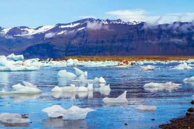 Soğuk ve berrak temmuz günü. Jokulsaurloun gölü. İzlanda. Suya garip buzdağları ve yüzen buz kütleleri yansıyor. Eko, kuzey ve fotoğraf turizmi kavramı