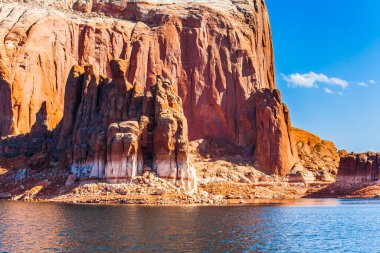 Powell Gölü 'nün gök mavisi suyu Anıt Vadisi' ndeki kayaların arasında. Büyük kayalıklar, kırmızı kumtaşı çıkıntıları. Utah ve Arizona eyaletlerinin sınırı. Etkin ve fotoğraf turizmi kavramı