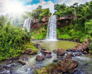 Sıcak tropikal güneş gürleyen şelaleleri aydınlatır. Arjantin 'deki Iguazu Şelalesi' nden iki hızlı şelale. Ekolojik ve ekolojik turizm kavramı