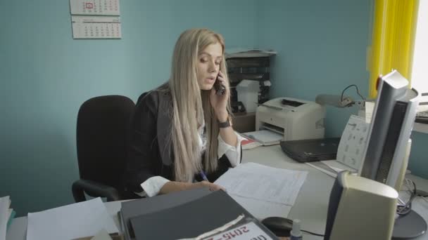 Hermosa joven mujer de negocios hablando por teléfono en imágenes de archivo de oficina video — Vídeos de Stock