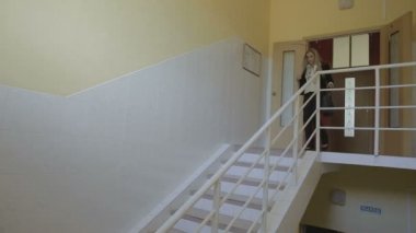 Güzel genç iş kadını mutlu bir şekilde merdivenlerden inip sonra iş stok görüntüleri video