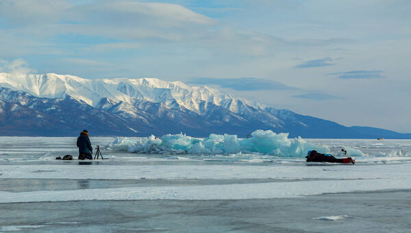 Фотограф снимает кубики льда. Красивый зимний пейзаж на Байкале
.