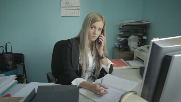 Όμορφη νεαρή γυναίκα μιλάμε στο τηλέφωνο στο γραφείο στοκ πλάνα βίντεο — Αρχείο Βίντεο