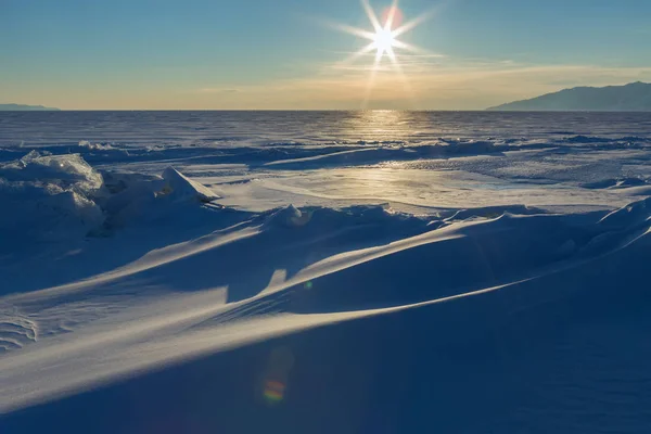 Sonnenuntergang über den schneebedeckten Eisbuckeln des Baikalsees — Stockfoto