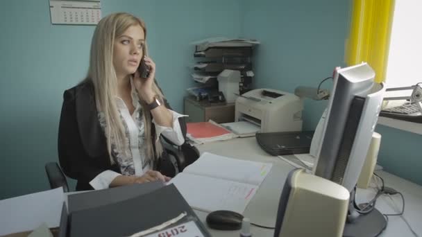 Hermosa joven mujer de negocios hablando por teléfono en imágenes de archivo de oficina video — Vídeos de Stock