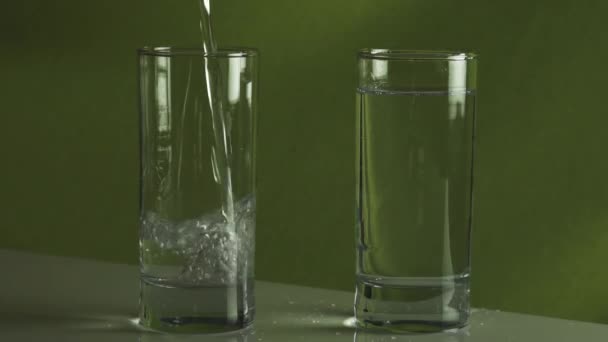 Spritzendes Wasser in Zeitlupe in Glas gießen — Stockvideo