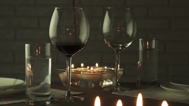 Vetro pieno di vino rosso a lume di candela romantica serata al rallentatore filmato di serie video — Video Stock