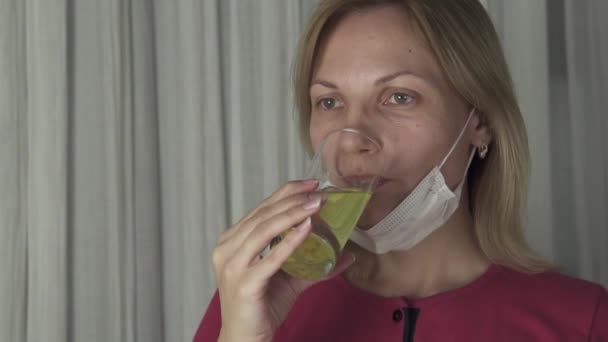 Frau trinkt aufbrausende Antipyretika, die in einem Glas Wasser aufgelöst sind. Video aus dem Gesundheitswesen in Zeitlupe — Stockvideo