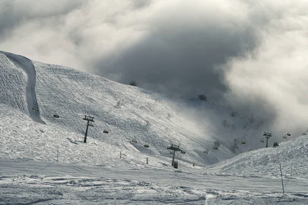 Pistes de ski dans les nuages sur la pente sud Aibga Ridge du Caucase occidental à Rosa Khutor Alpine Resort — Photo