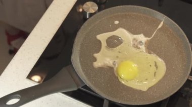 Ev hanımı çiğ yumurta kızartma tava içinde olup yanmış stok görüntüleri video böler