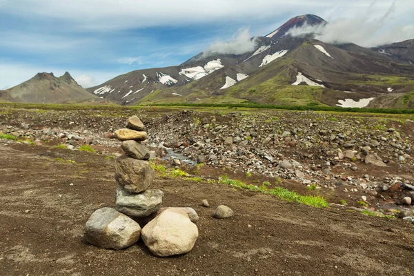 Pyramide de pierres sur un fond de volcan Avacha ou Avachinskaya Sopka sur la péninsule du Kamchatka Photo De Stock