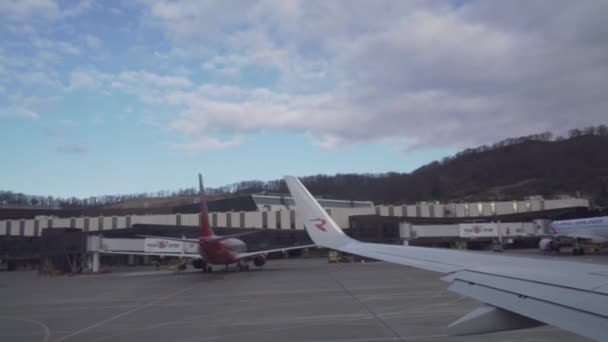 Taxning flygplan på banan i Sochi internationell flygplats se från fönstret arkivfilmer video — Stockvideo