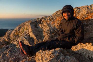 Neşeli turist gündoğumu dağın tepesinde Ilyas Kaya ağırlamaktadır..