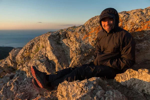 Cheerful tourist welcomes sunrise on top of mountain Ilyas Kaya. — Stock Photo, Image
