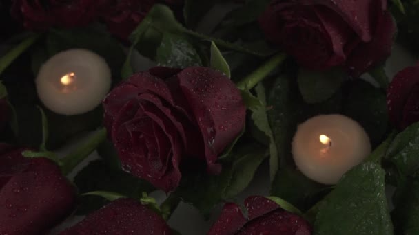 雨が降りそそぐキャンドルと赤いバラ悲しみ死んでスローモーション映像ビデオ — ストック動画