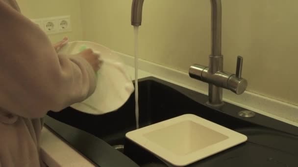 Домохозяйка моет посуду на кухне — стоковое видео