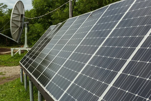 Solární panely a satelitní anténu pro energii a komunikaci v předměstí. — Stock fotografie