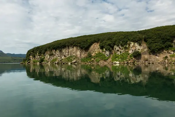 Bela costa de Kurile Lake é refletida na água . — Fotografia de Stock