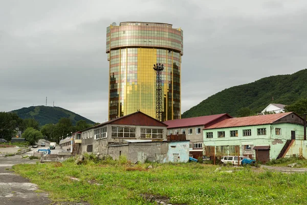 Többszintes modern üzletközpont Petropavlovszk-Kamcsatszkij-régi romos épületek között. — Stock Fotó