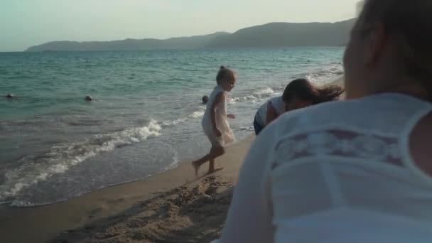 Glückliche Mutter und Töchter bauen eine Sandburg am Strand des Südchinesischen Meeres in Zeitlupe — Stockvideo