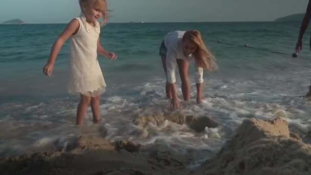 Madre felice e figlie costruiscono un castello di sabbia sulla spiaggia del Mar Cinese Meridionale, Yalong Bay stock footage video — Video Stock
