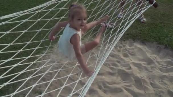 Menina feliz balançando em rede estoque filmagem vídeo — Vídeo de Stock