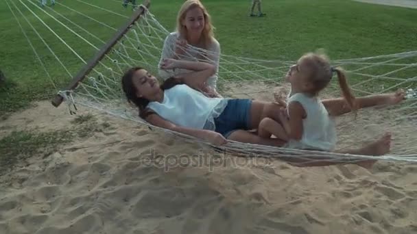 Feliz madre sacude a sus hijas en hamaca stock material vídeo — Vídeo de stock