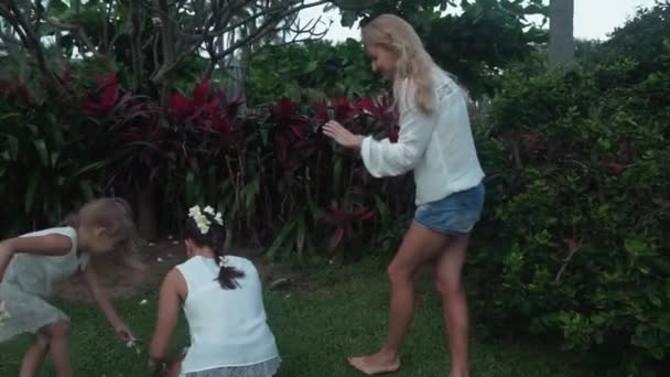 Moeder neemt foto's van haar dochters versierd met bloemen van de Plumeria stock footage video — Stockvideo