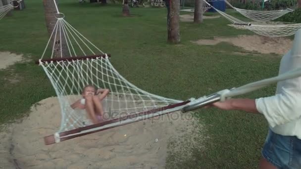 快乐妈妈在摇着她的女儿在吊床上慢动作素材视频 — 图库视频影像