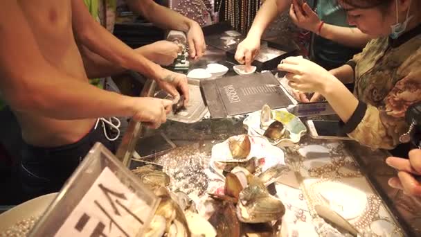 Продавец открывает раковину и производит видеосъемку из жемчуга — стоковое видео