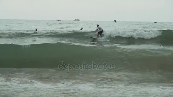 Серферы учатся управлять большими волнами Южно-Китайского моря на видео с пляжа Цунхай — стоковое видео
