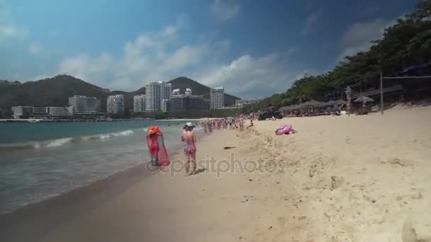 Zatłoczone plaża Dadonghai na turystyczne wyspa Hainan na ciepłej wiosny dzień Stockowy wideo — Wideo stockowe