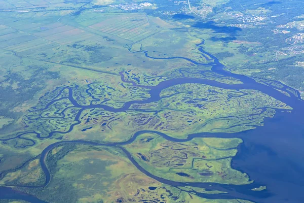 Coast of the Kamchatka Peninsula is cut by water arteries of Pacific Ocean. View from plane. — Stock Photo, Image