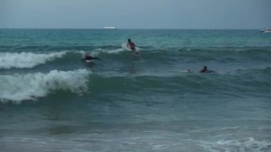 Güney Çin Denizi Dadonghai Beach stok görüntüleri video üzerinde büyük dalgalar fethetmek sörfçü öğrenin