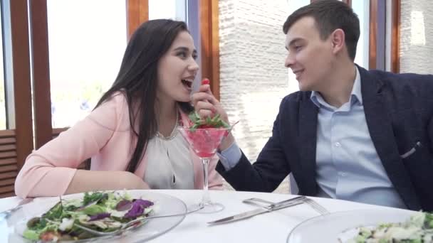 Par i kärlek vid restaurang supper, en kille som utfodring en flicka med en berry slowmotion arkivfilmer video — Stockvideo