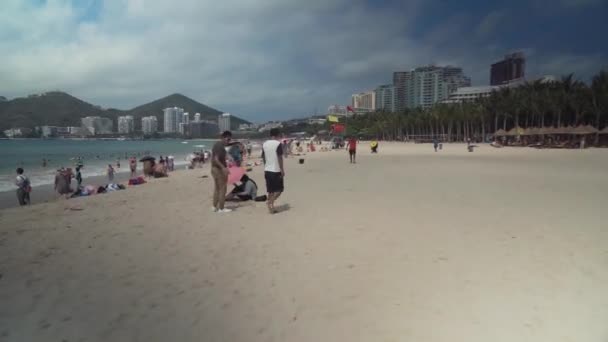 Zatłoczone plaża Dadonghai na turystyczne wyspa Hainan na ciepłej wiosny dzień Stockowy wideo — Wideo stockowe