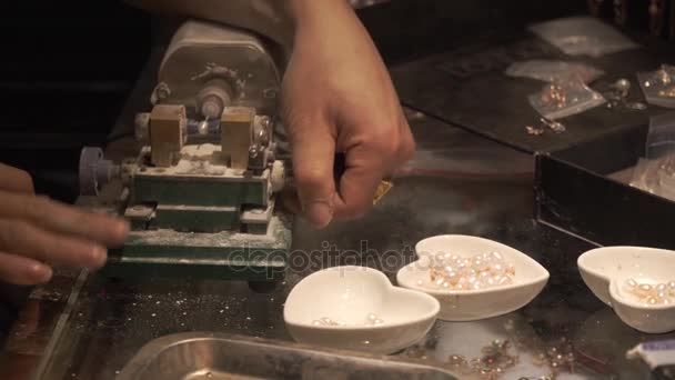 Verkäufer auf der Maschine macht ein Loch im Perlenstock Filmmaterial Video — Stockvideo