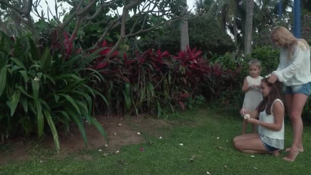 Mamá decora el pelo de las hijas con flores de Plumeria material de archivo de vídeo — Vídeos de Stock