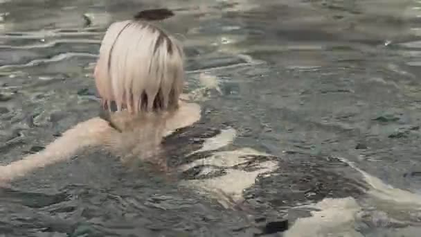 Menina bonita nadando no estoque da piscina filmagem vídeo — Vídeo de Stock