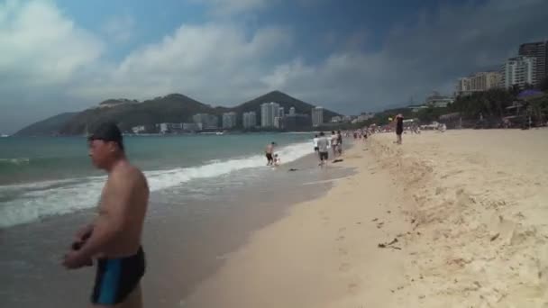 Zatłoczone plaża Dadonghai na turystyczne wyspa Hainan na ciepłej wiosny dzień Stockowy wideo — Wideo stockowe