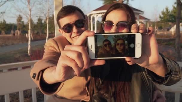 Пара влюбленных на улице делает селфи на видео, снятом на iPhone — стоковое видео