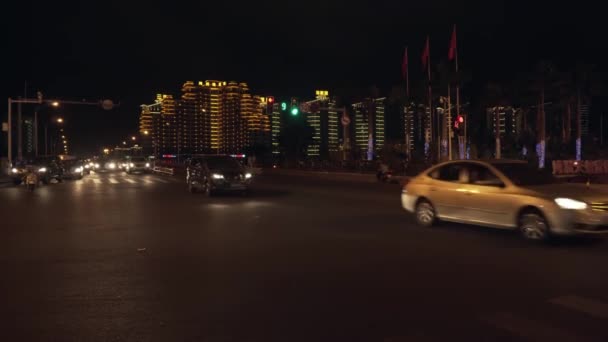 Transport auf einer belebten nächtlichen Kreuzung in der Innenstadt von Sanya Stock Footage Video — Stockvideo