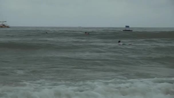 Серферы учатся управлять большими волнами Южно-Китайского моря на видео с пляжа Цунхай — стоковое видео