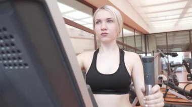 Eliptik bir eğitmen spor salonu stok görüntüleri video içinde genç kız trende