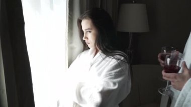 Pencerenin dışındaki manzara sevgi dolu çift beyaz kat olarak bakar, adam kız bir bardak kırmızı şarap yavaş hareket hisse senedi görüntüleri video getiriyor.