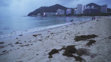 Çöp Dadonghai sahilde turist Hainan Adası stok görüntüleri video akşam yükselince sonra kum