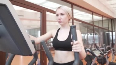 Eliptik bir eğitmen spor salonu stok görüntüleri video içinde genç kız trende