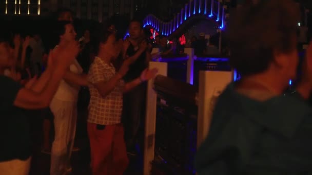 Este pedig táncok, a kínai és a turisták Sanya folyó stock footage videóinak töltésén — Stock videók