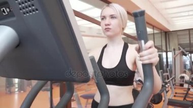 Eliptik bir eğitmen spor salonu stok görüntüleri video içinde genç kız trende